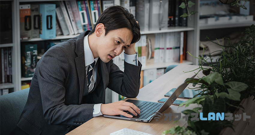 PCに向かい悩む男性社員