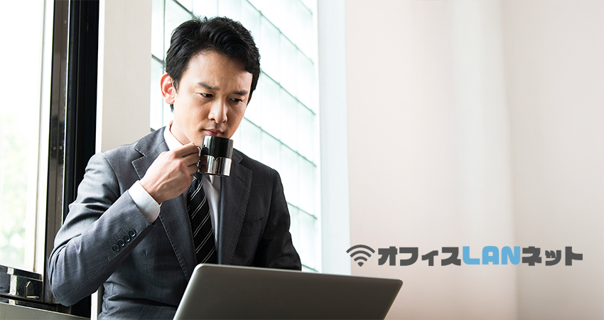 困惑しながらPCを見る男性